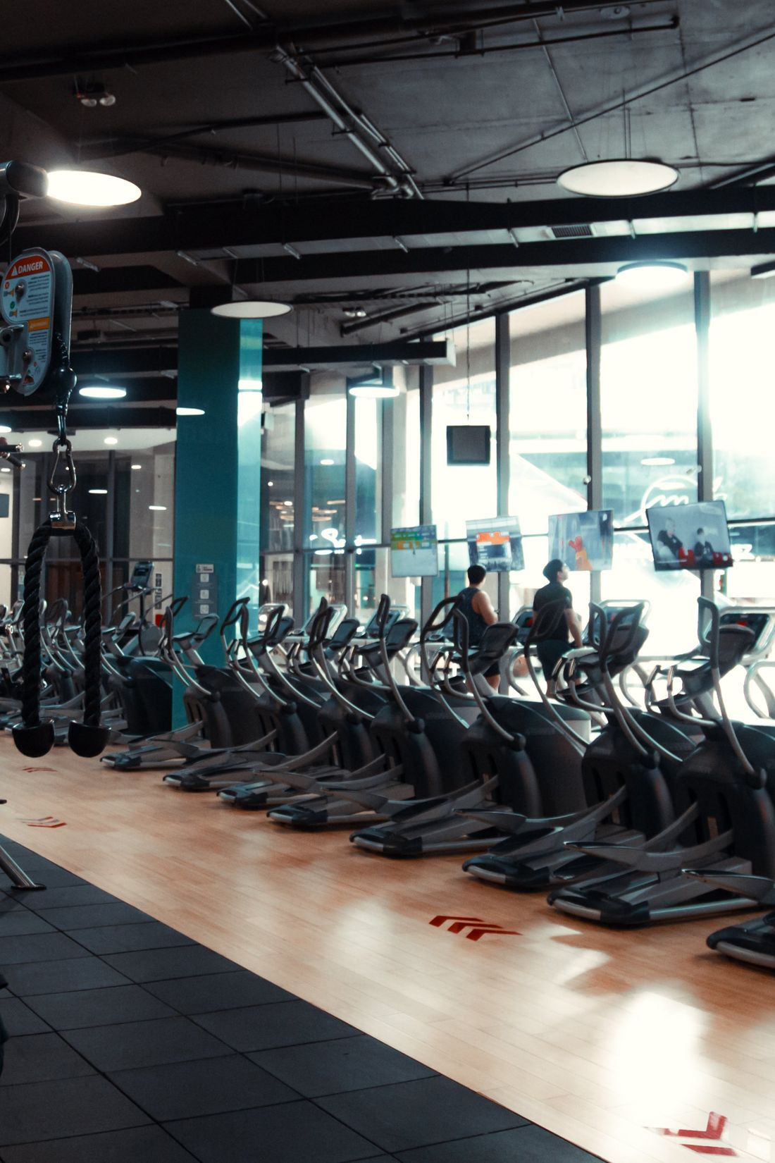 Zona de cardio con elípticas junto a los ventanales